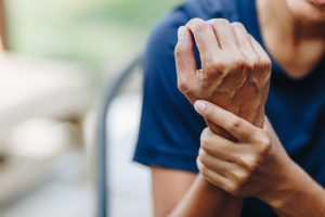 arthritis hand pain holding wrist woman