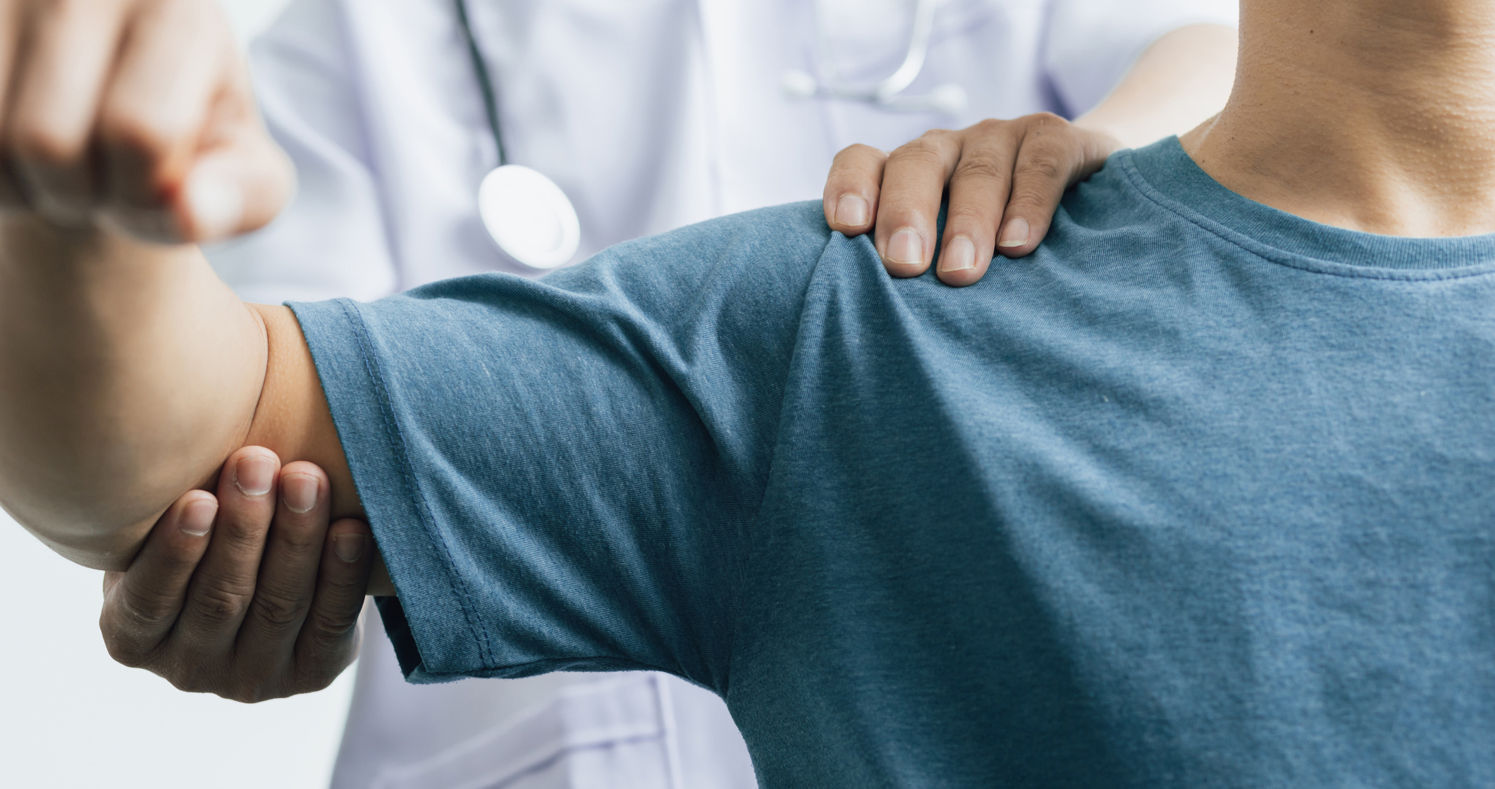 A man with shoulder pain goes to the doctor, The doctor diagnoses the patient's arm pain and shoulder pain. Concept of physical therapy and rehabilitation.