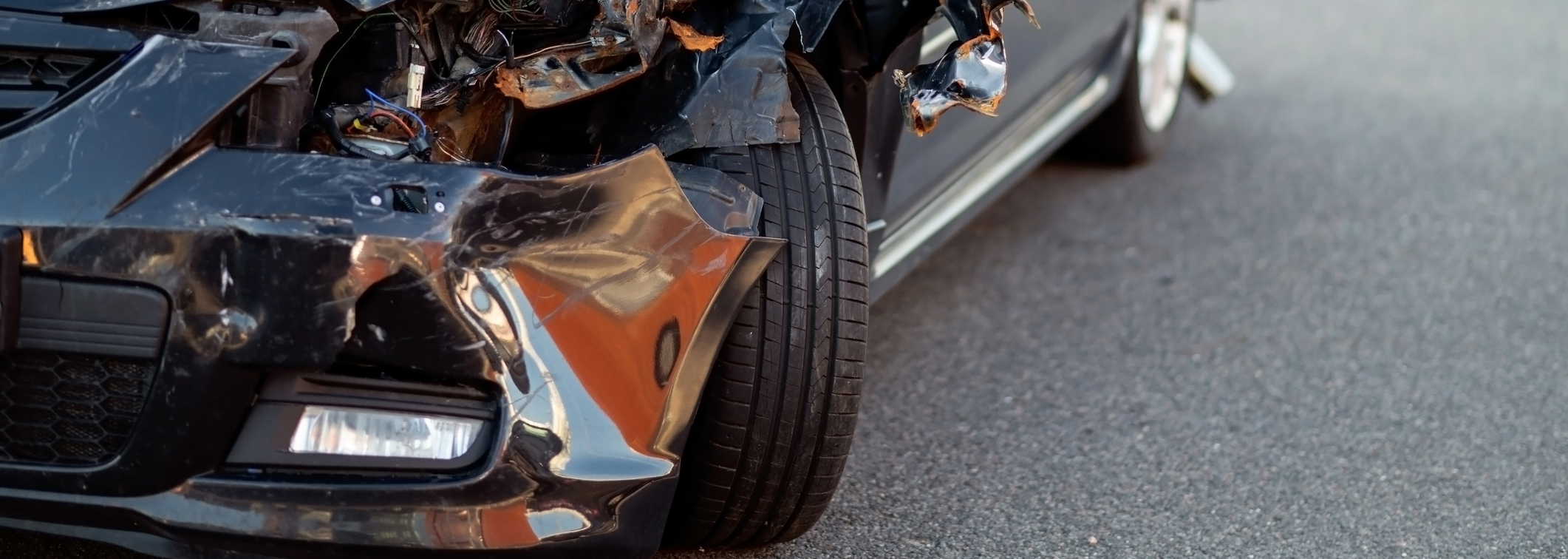 Close-up of damaged car part after accident showing broken metal and scratches